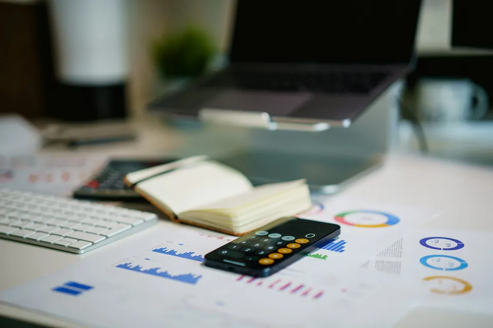 Accounting documents and a laptop on a desk