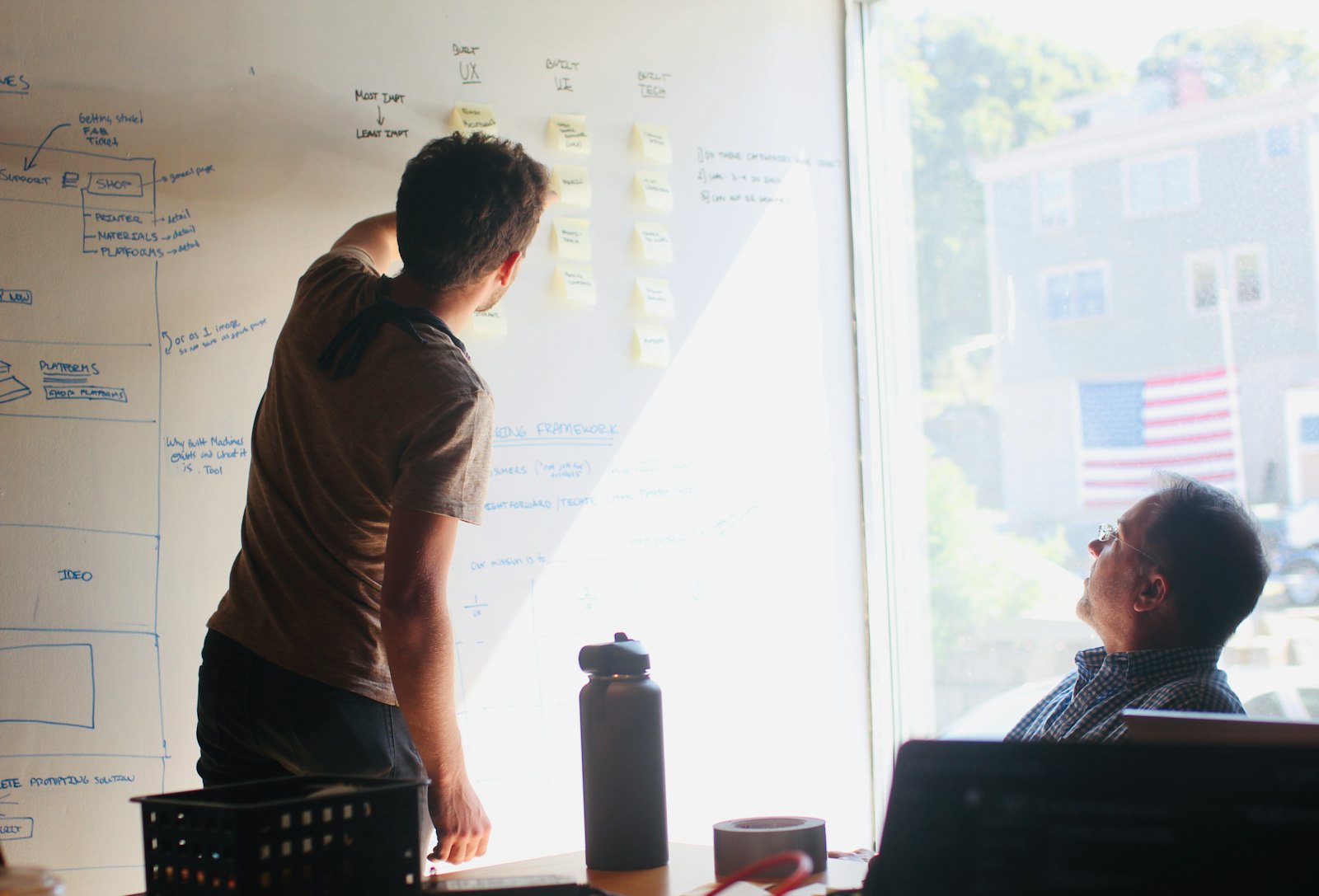 A designer sketching a wireframe on a whiteboard